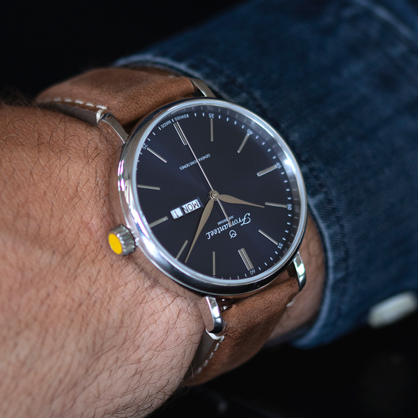 "Man showcasing a Fromanteel Day-Date Blue watch with a sophisticated blue dial and brown suede leather strap.